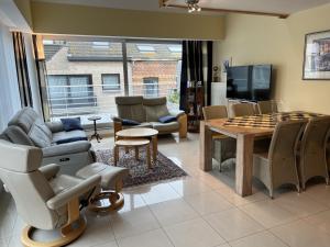 a living room with a couch and a table with chess at Residentie Alegria Ostende in Ostend