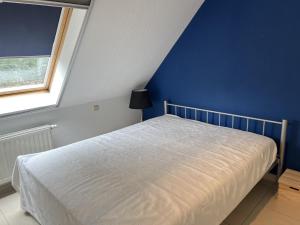 Schlafzimmer mit einem Bett mit blauer Wand in der Unterkunft Residentie Alegria Ostende in Ostende