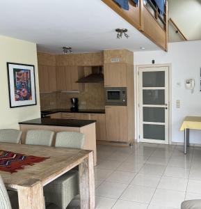 eine Küche und ein Esszimmer mit einem Holztisch in der Unterkunft Residentie Alegria Ostende in Ostende