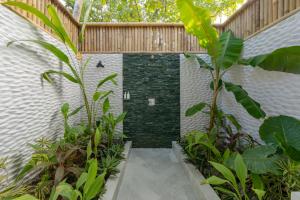 a shower in the middle of a building with plants at Malahini Kuda Bandos Special Offer Begin your island escape with ease airport pick up and return by shared speedboat at just USD 50 per person stays stay untill end October 2026 in North Male Atoll