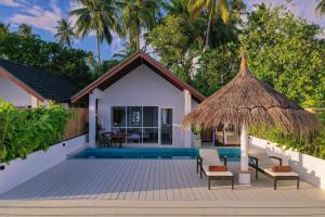 a villa with a swimming pool and a resort at Malahini Kuda Bandos Resort in North Male Atoll