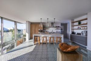 una cucina con un tavolo e alcune sedie in una stanza di 41 on Beachy Head - Luxury Villa 100m from the beach a Plettenberg Bay Altre 37 foto
