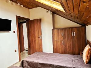 a bedroom with a bed and wooden cabinets and a tv at RELAX - Guest House Varshets in Varshets