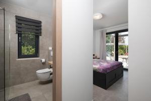 łazienka z łóżkiem, toaletą i prysznicem w obiekcie Luxury design Villa Maell with private pool and high level of privacy - WiiBuk w mieście Šišan