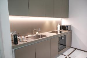 cocina con fregadero y microondas en The Executive Residence - Kirchberg en Luxemburgo