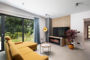 salon z żółtą kanapą i telewizorem w obiekcie Luxury design Villa Maell with private pool and high level of privacy - WiiBuk w mieście Šišan