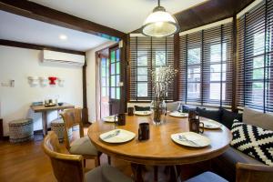 a dining room with a wooden table and chairs at Tolani Northgate Villa Chiang Mai in Chiang Mai