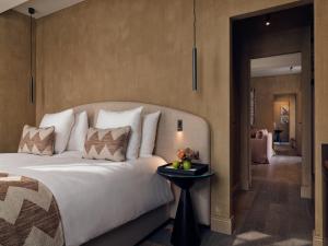 um quarto com uma cama grande e uma mesa lateral em Botanic Sanctuary Antwerp - The Leading Hotels of the World em Antuérpia