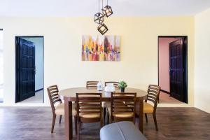 a dining room with a table and chairs and a painting at R S Home in Tawau