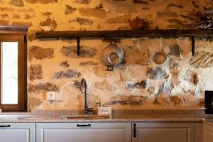 a kitchen with a sink and a stone wall at Bilbao Nature with parking by Aston Rentals in Erandio