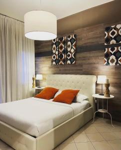 1 dormitorio con 1 cama blanca grande con almohadas de color naranja en Central Suite Bed&Breakfast en Bolonia