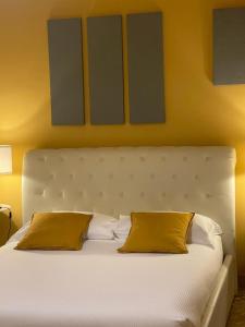 Central Suite Bed&Breakfast في بولونيا: سرير ابيض كبير عليه وسادتين صفراء