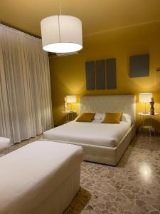 Central Suite Bed&Breakfast في بولونيا: سريرين في غرفة بجدران صفراء