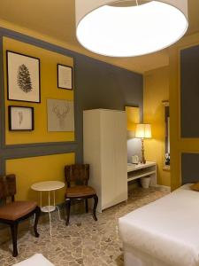 Central Suite Bed&Breakfast في بولونيا: غرفة نوم بسرير وطاولة وكراسي