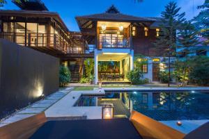 a house with a swimming pool in front of a house at Tolani Northgate Villa Chiang Mai in Chiang Mai