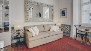 a living room with a couch and a table and a mirror at Madalena City Center in Lisbon