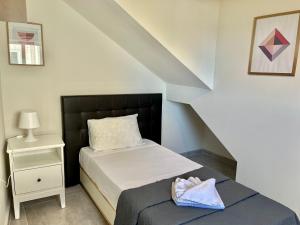 - une petite chambre avec un lit et une table de nuit dans l'établissement Graziosa Court, à Marsaskala