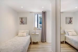 Un dormitorio con dos camas y un espejo. en Madeira Sun, en Funchal 14 fotos más