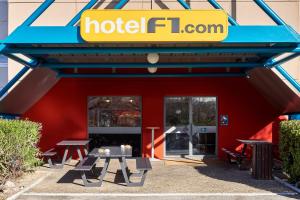 hotel förör restauracja z stołami piknikowymi przed nim w obiekcie hotelF1 Rouen Zénith Parc Expo w mieście Saint-Étienne-du-Rouvray