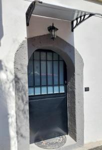 una porta nera su un edificio bianco con una lampada di City Wonders B&B a Napoli