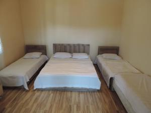 two beds in a small room with wooden floors at OK house! in Kobuleti