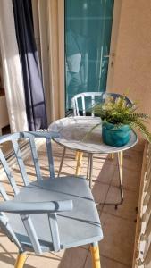 a table and chairs on a patio with a potted plant at Caesarea - Suite Paradise - C113 - סוויט פרדייס - נאות גולף, קיסריה in H̱efẕi Bah