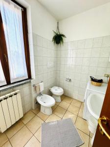 Baño blanco con aseo y lavamanos en Casa Nonna Elide, en Besozzo