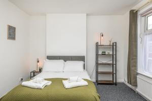1 dormitorio con 1 cama con 2 toallas en Wood House - 5 Beds, Suitable for contractors en Kettering