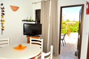 a dining room with a table and a television at Casa da Horta, Vale carro Olhos de Agua in Albufeira