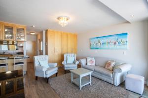 sala de estar con sofá y 2 sillas en Hibernian Towers 309 Strand - Luxury Self Catering en Ciudad del Cabo