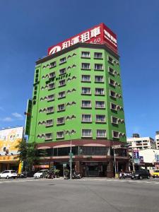 ein grünes Gebäude mit einem Schild darüber in der Unterkunft Hualien Wow Hostel in Hualien