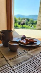 un tavolo con un piatto di cibo e una tazza di caffè di 9CENTO B&B and Private SPA a Montenero Val Cocchiara