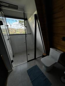 a small bathroom with a toilet and a window at Cabana Jequitibá in Maria da Fé