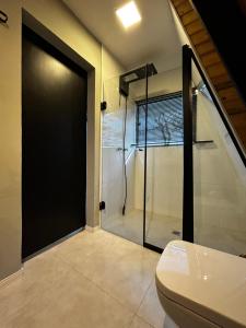 a bathroom with a shower and a toilet in it at Cabana Jequitibá in Maria da Fé