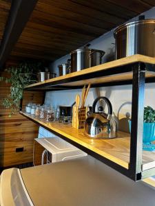 a kitchen with wooden shelves with pots and pans at Cabana Jequitibá in Maria da Fé