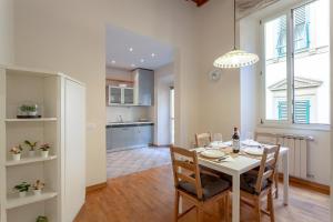 uma sala de jantar e cozinha com mesa e cadeiras em La Perla Del Borgo Apartment em Florença