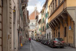 uma rua estreita com edifícios e um carro estacionado nela em La Perla Del Borgo Apartment em Florença