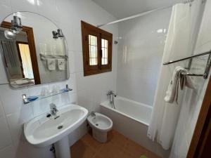 uma casa de banho com um lavatório, uma banheira e um WC. em El retiro hotel rural em Moratalla