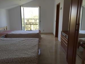 Cette chambre comprend 2 lits et une fenêtre. dans l'établissement Villa Olive Tree with Private Pool, à Luštica
