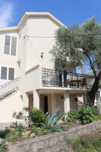 - un bâtiment blanc avec un balcon et un arbre dans l'établissement Villa Olive Tree with Private Pool, à Luštica