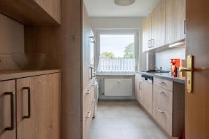 a kitchen with wooden cabinets and a window at Private Apartment in Hannover