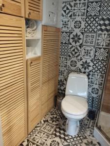 a small bathroom with a toilet and black and white tiles at Apartament 4 plus 1 w Karkonoszach in Jelenia Góra