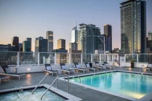 een zwembad op het dak met stoelen en een skyline van de stad bij Sunny & Spacious 2BDR & 1BTH in Downtown LA in Los Angeles