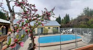 a house with a swimming pool and a fence at Cabaña Casa Amarilla in Ciudad Lujan de Cuyo
