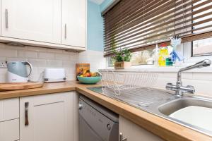 a kitchen counter with a sink and a window at Rivermead in Horsham