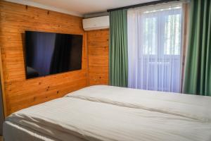 um quarto com uma cama, uma televisão e uma janela em CASA LAVY em Baile Felix