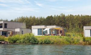 une maison moderne sur la rive d'une rivière dans l'établissement Terhills Resort by Center Parcs, à Dilsen-Stokkem