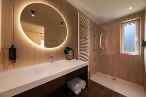 Terhills Resort by Center Parcs في ديلسن - ستوكيم: حمام مع حوض ومرآة