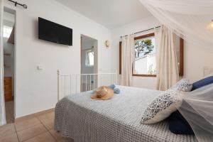 un dormitorio con una cama con un animal de peluche en Can Miquelet en Port d'Alcudia