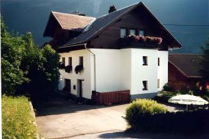 ein weißes Haus mit einem schwarzen Dach und einem Regenschirm in der Unterkunft Apartment Jerzens 1 in Jerzens